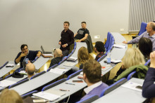 person standing in room talking to other people