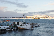 partly ice covered fishing boat at pier