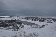 snow covered beach with village in the background