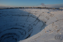 very deep mining pit in front of city skyline
